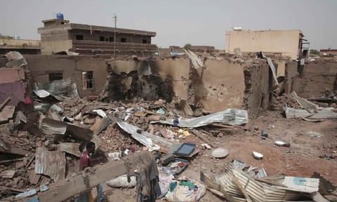 A man walks by a house hit in recent fighting in Khartoum, Sudan, an area torn by fighting between the military and the notorious paramilitary Rapid Support Forces, on April 25, 2023 (AP) 