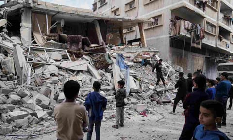 Palestinians inspect the damage after an Israeli army airstrike in Gaza City (AP)