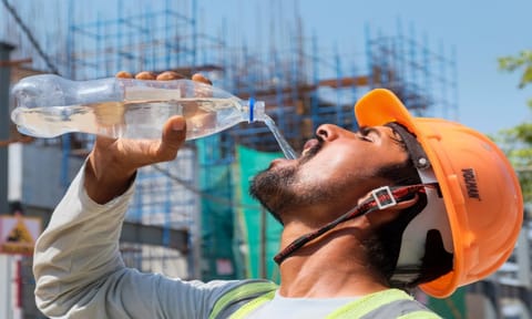 A worker drinks water to quench his thirst during a hot summer day, at a construction site, in Gurugram (PTI)