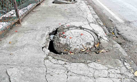 Yawning gaps are seen on the sides of the damaged stormwater drain lid on Luz Avenue 