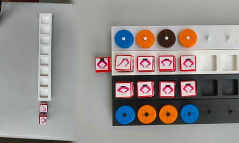 Atam incorporates physical components such as dice, dials, and holders