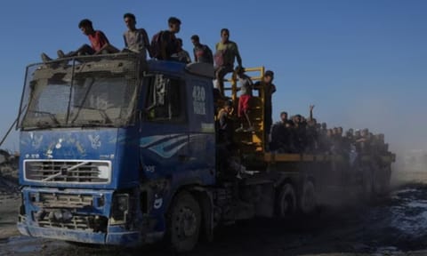 Palestinians ride on a truck used to transport humanitarian aid as it drives to Gaza City from the northern Gaza Strip (AP)