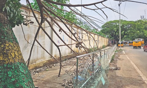 Portion of the footpath along Perambur High Road filled with tree branches and legacy waste