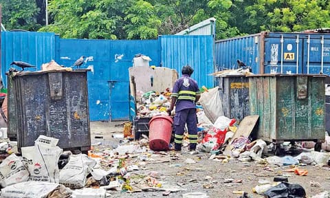 A cleanliness worker handles waste without gloves at a collection point on Thanthai Periyar Nagar 1st Street 
