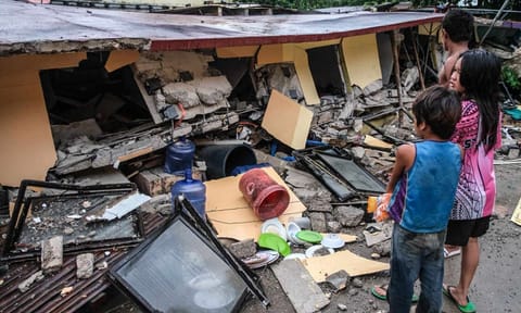 People look at a collapsed building in Bogo City, Cebu province, Philippines Wednesday, Oct. 1, 2025 after an offshore earthquake on late Tuesday. 