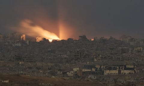 A fire erupts amid buildings destroyed during Israeli ground and air operations