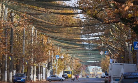 Local residents go along the street covered with an anti-FPV-drone net in the frontline city of Kherson, Southern Ukraine. (Photo: AP)