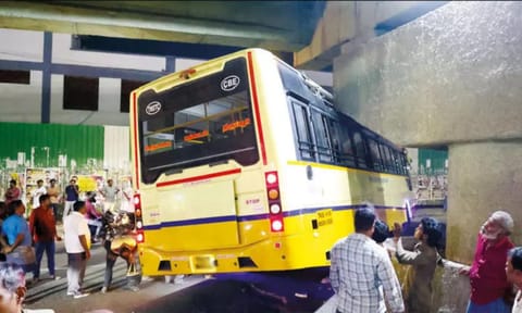 government bus heading to Udumalpet got stuck under a flyover pillar while exiting the terminal.