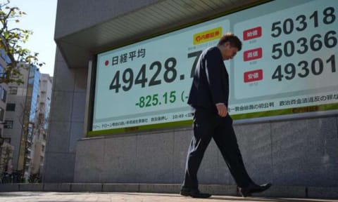 A person walks in front of an electronic stock board showing Japan's Nikkei index at a securities firm Monday, Dec. 1, 2025, in Tokyo (AP) 