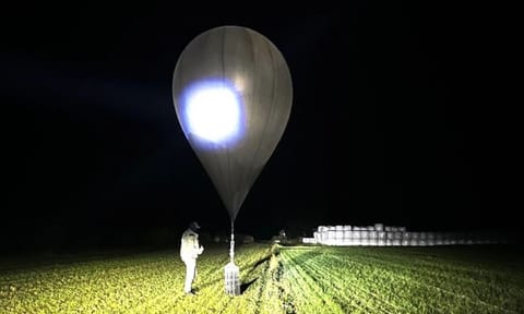 Officer inspects a balloon used to carry cigarettes into Lithuania, because Belarussian smugglers often use them to ferry the contraband into the European Union (AP)