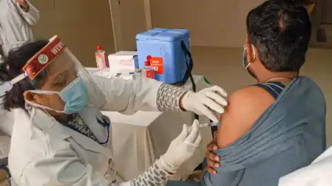 A health worker giving Covid jab to a person