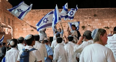 Members of Jewish youth movements dance and wave Israeli flags on the eve of Jerusalem Day