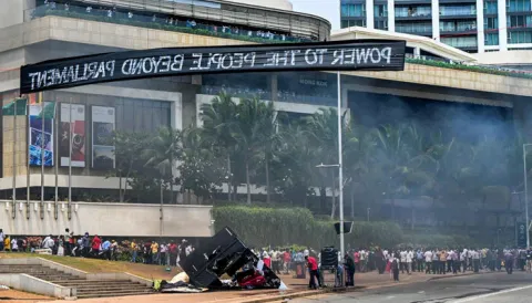 Demonstrators and government supporters clash outside the President's office in Colombo