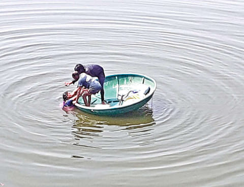 Two men rescuing the woman who jumped into Cauvery river