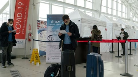 Travellers look at Covid-19 results after being tested inside JFK International airport in New York