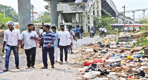 Residents and rail users cross the garbage-filled passageway near Pallavaram railway station