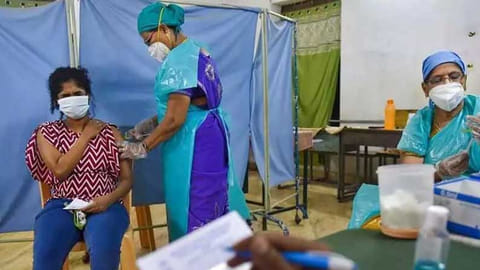 A healthworker administering Covid vaccine to a women