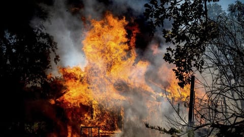 Flames from the Oak Fire consume a home on Triangle Road in Mariposa County, Calif