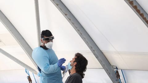 A health worker administers a test for Covid on a member of the public at the Bondi Beach drive-through testing centre during a Covid outbreak lockdown in Sydney.