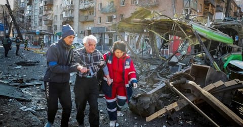 People and medics help a wounded resident of a house destroyed by shelling as Russia's attack on Ukraine