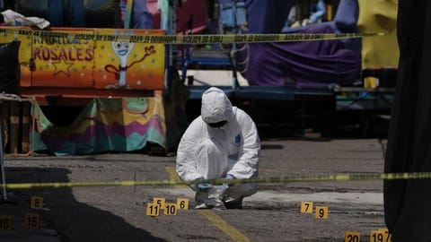 A forensics investigator works the scene of a massive shootout
