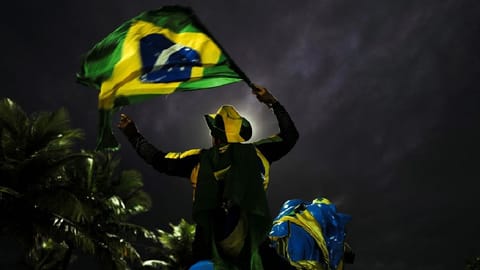 A supporter of Brazil's President Jair Bolsonaro reacts while gathering with fellow supporters outside Bolsonaro's home