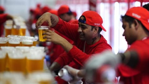 Staff member holds a beer at a fan zone ahead of the FIFA World Cup, in Doha, Qatar.