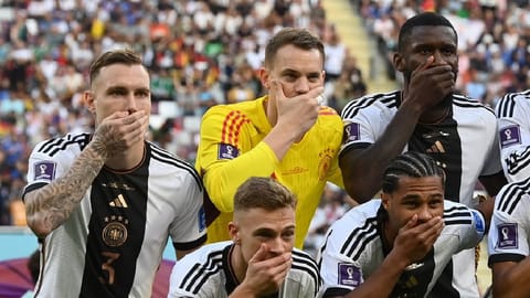 Germany players cover their mouths as they pose for a team group photo before the match