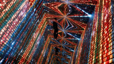 A visitor is pictured in front of an immersive art installation titled "Machine Hallucinations ? Space: Metaverse"