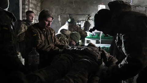 Ukrainian servicemen give the first aid to a soldier wounded in a battle
