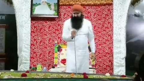 Ram Rahim cutting the cake with the sword