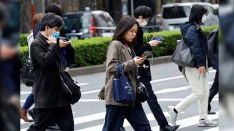 Commuters make their way on the first day of the Japanese government's relaxation of official guidance on masks as it emerges from the COVID-19 pandemic, in Tokyo, Japan March 13, 2023