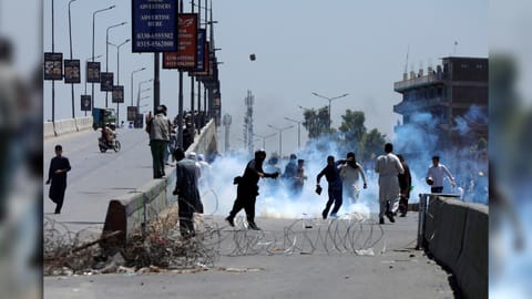 Supporters of Pakistan's former Prime Minister Imran Khan throw stones towards police during a protest against Khan's arrest, in Peshawar, Pakistan, May 10, 2023
