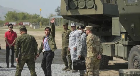 Philippine President Ferdinand Marcos Jr. waves beside a U.S. M142 High Mobility Artillery Rocket System (HIMARS) during a Combined Joint Littoral Live Fire Exercise at the joint military exercise called "Balikatan," Tagalog for shoulder-to-shoulder in a Naval station in Zambales province, northern Philippines