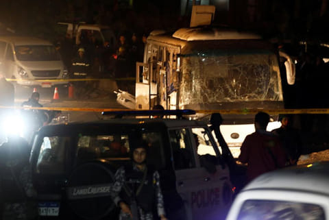Police officers inspect a scene of a bus blast in Giza, Egypt