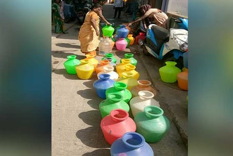 Alandur residents with water cans on the road