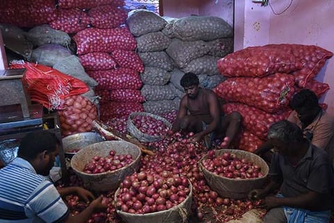 Workers at Koyambedu market seggregate onions amid the rising prices, on Thursday