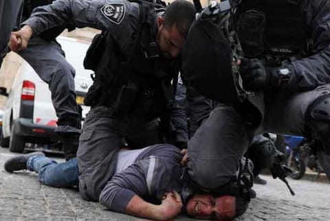 Israeli police officers detain a Palestinian protestor during scuffles
