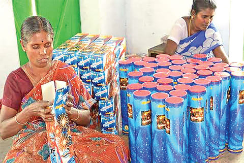 Women workers engaged in packing crackers at a unit in Sivakasi