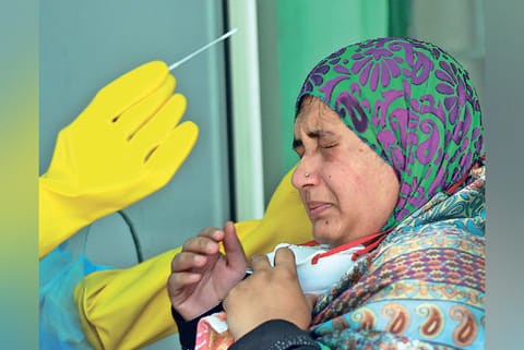 A doctor takes swab from a woman at a Walk-In Sample Kiosk (WISK) in a government hospital, Chennai
