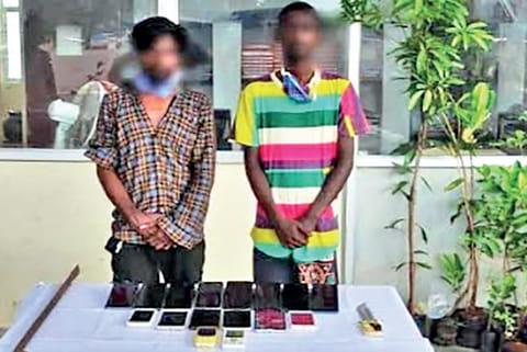 Jayaraj and Raja with the seized mobile phones