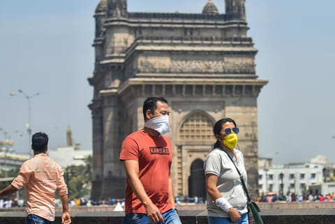 People wear protective masks in view of coronavirus pandemic at the Gateway of India in Mumbai