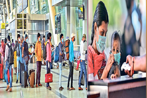 Passengers waiting to show tickets and enter the airport; staff checking temperature of passengers