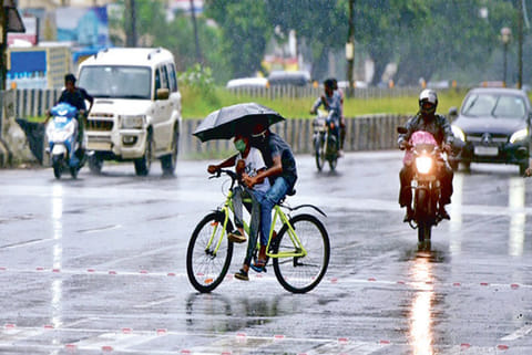 Vehicles ply during a mild drizzle in city