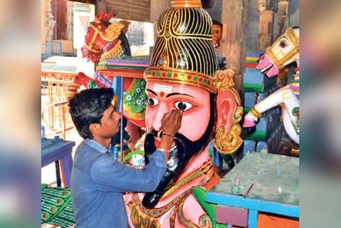 An artisan giving final touches to a vahanam.