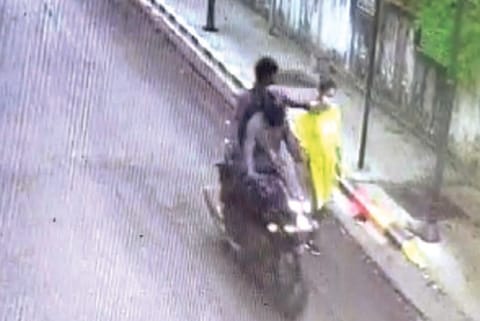 CCTV grab of the snatchers pushing woman