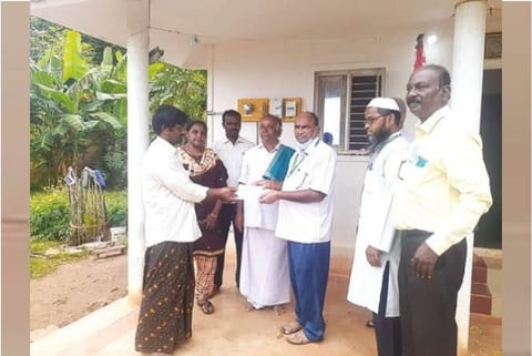A Kettakadu hamlet resident receives power card for first time from EB officials in Yelagiri