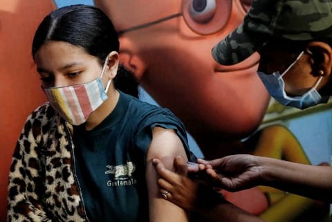 A health worker administers vaccine (Credit: Reuters)