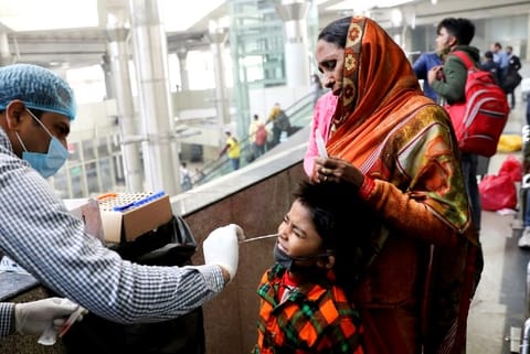 A healthcare worker collects swab test from a boy (Credit: Reuters)