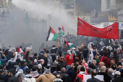 Protesters are sprayed with water near the US embassy in Awkar east of Beirut, Lebanon